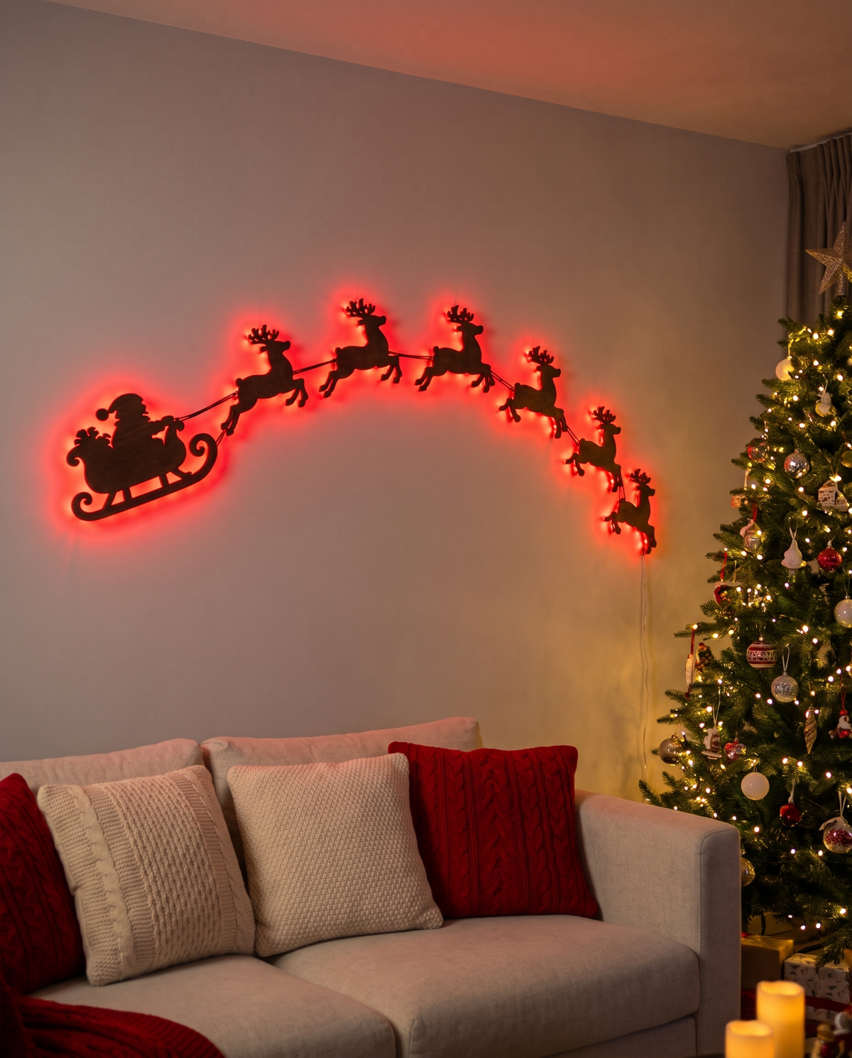 Traîneau du Père Noël et rennes éclairés en rouge avec la télécommande, au-dessus d'un canapé